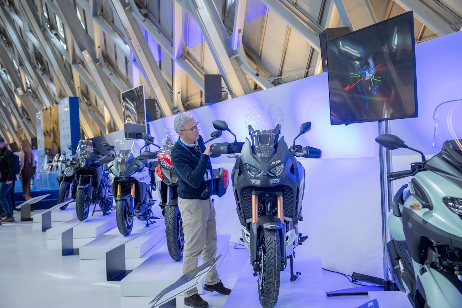 Visitor next to a motorcycle and an explanatory screen at MotoTech 2024